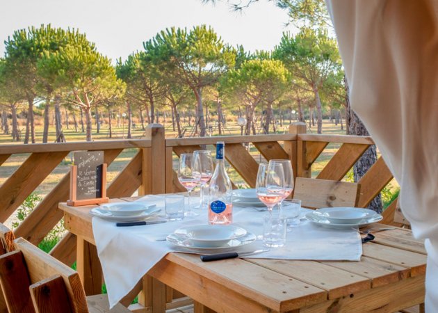 Tavolo apparecchiato all'aperto con vista alberi.