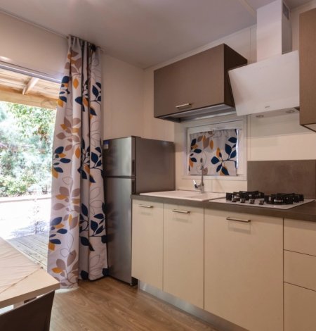 Cucina moderna con tende floreali e frigorifero.