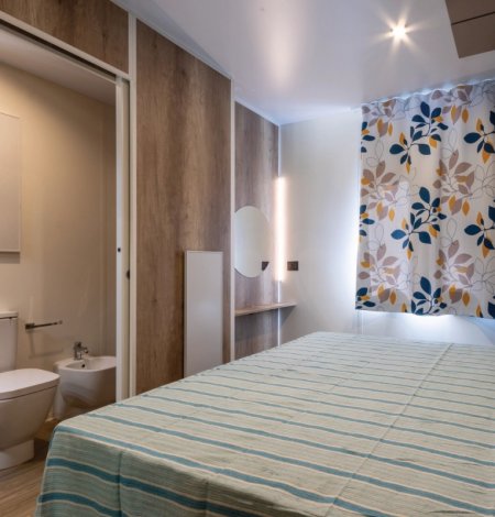 Camera da letto con bagno integrato e tende floreali.