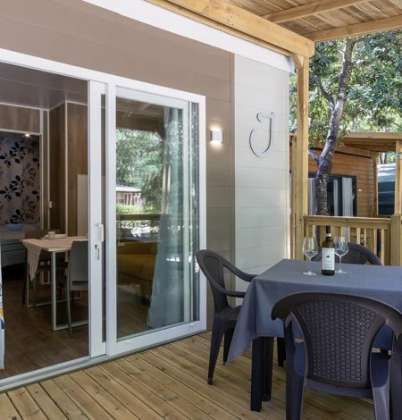 Veranda con tavolo apparecchiato e sedie.