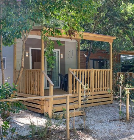 Bungalow in legno con veranda immerso nel verde.
