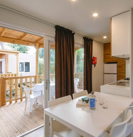 Interno luminoso con tavolo bianco vicino a veranda.