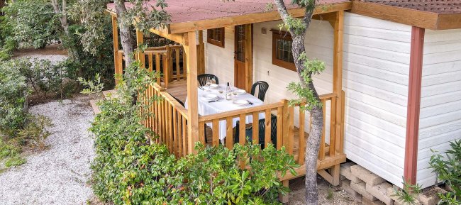 Veranda di una casa bianca con tavolo da pranzo.