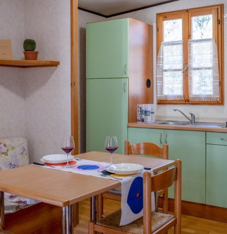 Cucina con tavolo e sedie in legno chiaro.