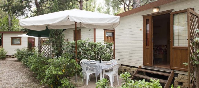 Bungalow con terrazza e tavolo all'aperto.