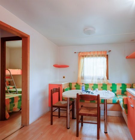 Soggiorno con tavolo, sedie e divano colorato.