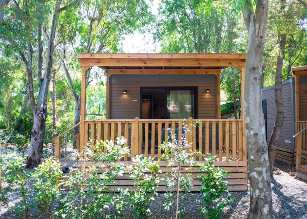 Casa in legno con veranda immersa nel verde.