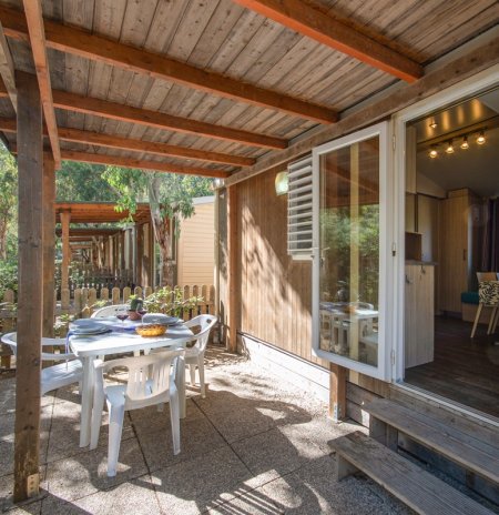 Veranda con tavolo bianco e sedie di plastica.