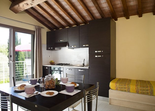 Cucina moderna con tavolo apparecchiato e divano.