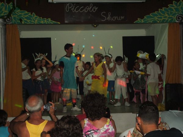 Bambini in costume recitano in un piccolo spettacolo teatrale. Pubblico in sala.