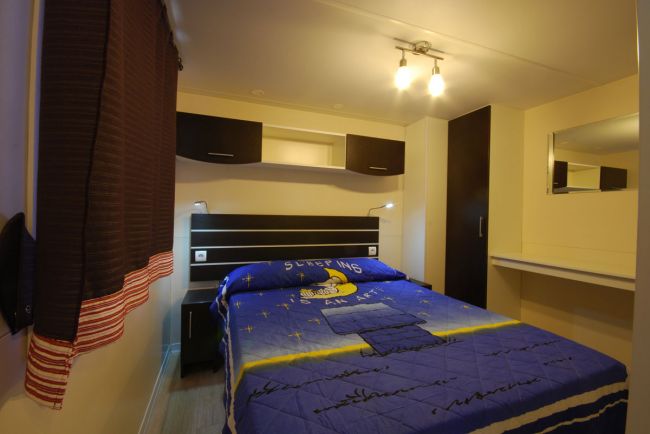 Camera da letto con letto matrimoniale e armadio scuro.