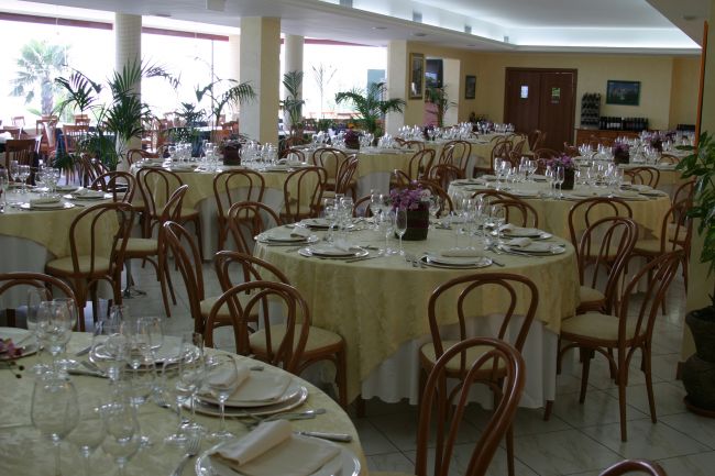 Sala da pranzo elegante con tavoli apparecchiati.