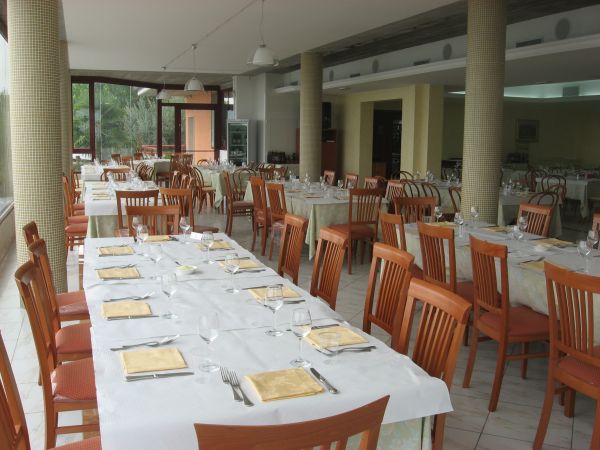 Sala da pranzo vuota con tavoli apparecchiati.