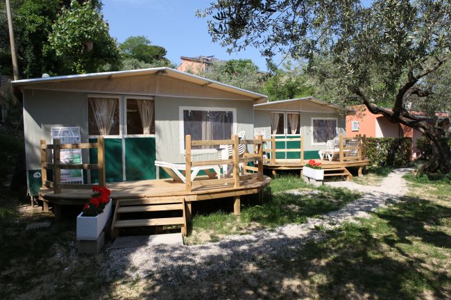 Bungalow in legno con verande in un giardino.