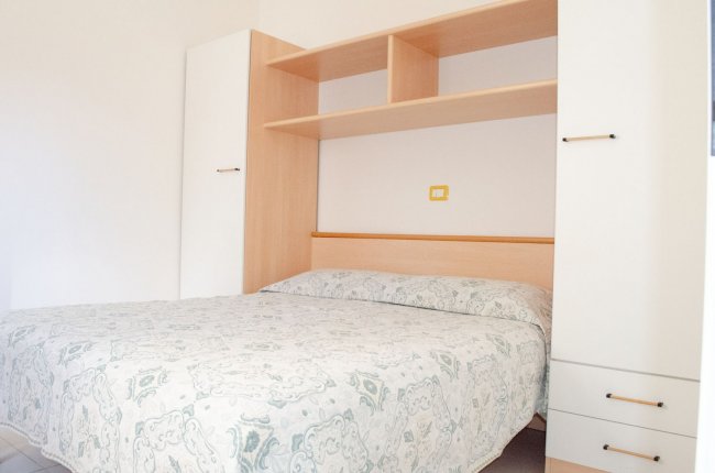 Camera da letto con letto matrimoniale e armadi a parete.