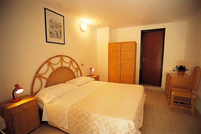 Camera da letto con letto matrimoniale, armadio e comodini.