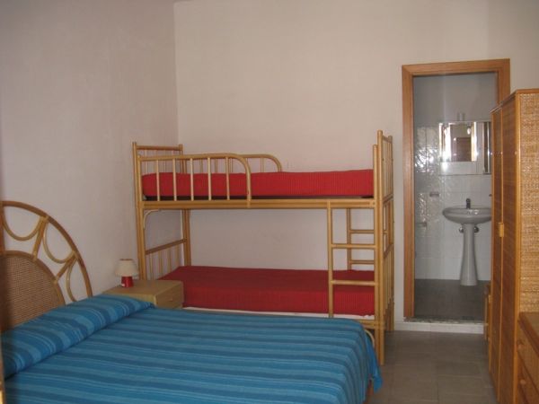 Camera con letto matrimoniale, letto a castello e bagno.