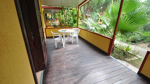 Veranda con tavolo e sedie bianche.