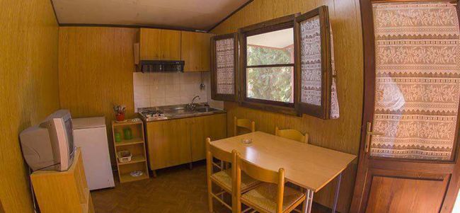 Cucina con tavolo in legno e sedie.