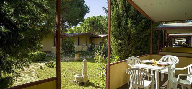 Veranda con tavolo, sedie e vista giardino.