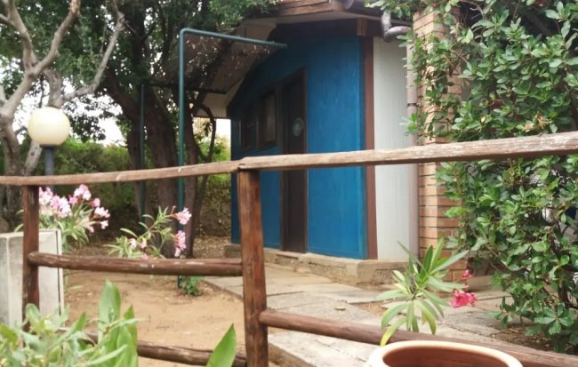 Casa blu con giardino e staccionata di legno.