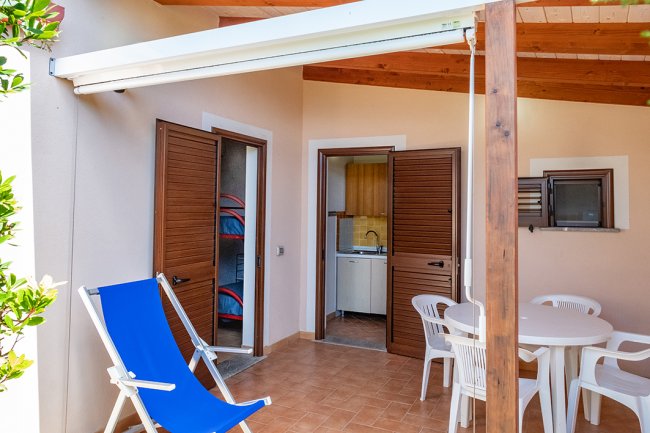 Patio con tavolo rotondo e sedia a sdraio blu.