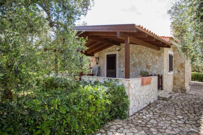 Casa in pietra immersa tra gli alberi.