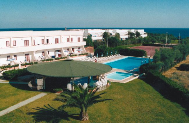 Piscina all'aperto con gazebo e vista sul mare.