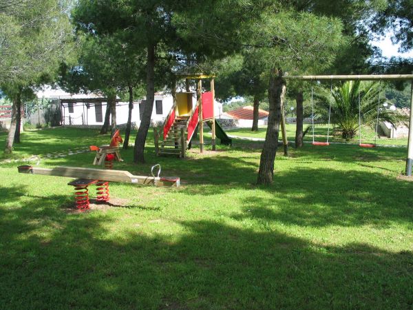 Area giochi con scivolo, altalene e bilico.