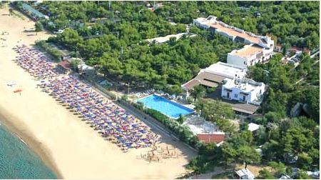 Vista aerea di un resort con spiaggia e piscina.