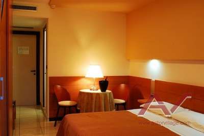 Una camera d'albergo accogliente con letto, lampada e tavolino.