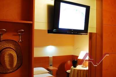 Camera d'hotel con TV a schermo piatto e due letti.