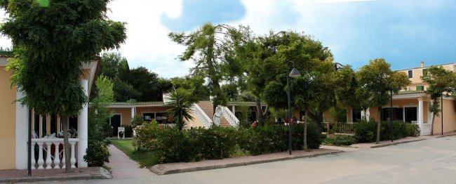 Giardino con edifici e alberi.