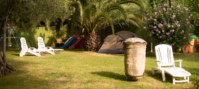 Giardino con sdraio, tenda e giochi.