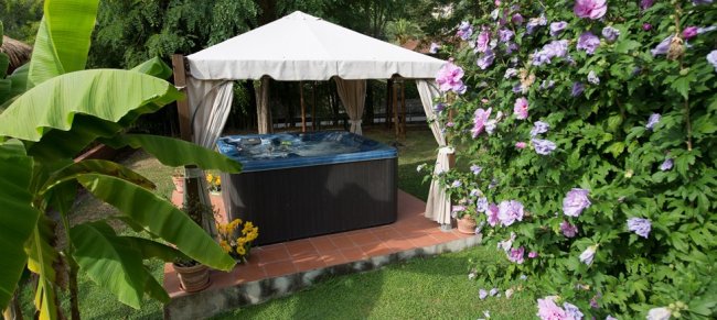 Vasca idromassaggio coperta in giardino.