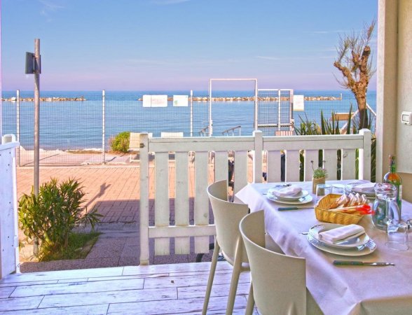 Tavolo apparecchiato su terrazza vista mare.