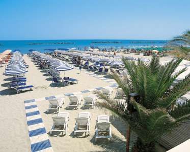 Spiaggia con ombrelloni e lettini allineati, vista mare.