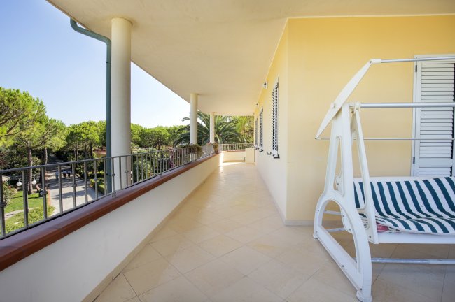 Terrazza con dondolo e vista su alberi.