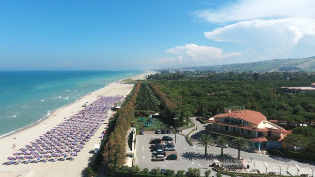 Spiaggia con ombrelloni e mare azzurro.