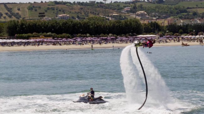 Uomo su una tavola a getto d'acqua in mare.