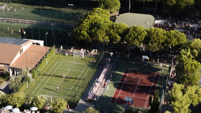 Campi da gioco e tennis circondati da alberi.