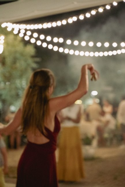 Persona che balla sotto le luci in una festa serale.