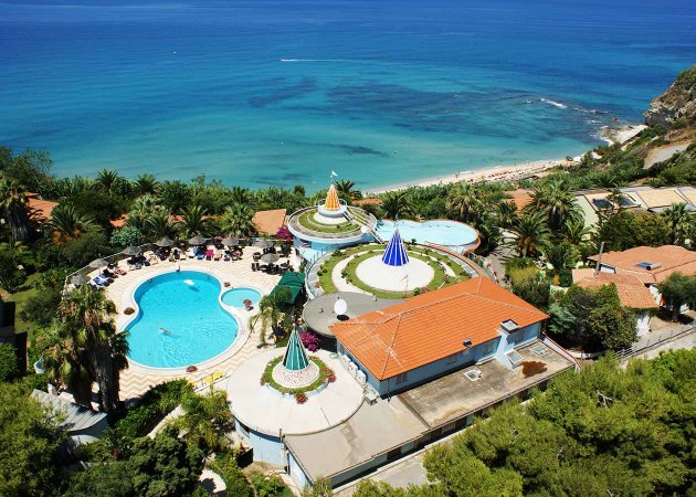 Veduta aerea di un resort con piscina e vista mare.