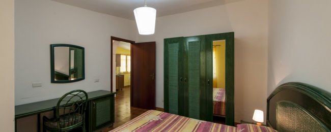 Camera da letto con armadio verde e scrivania.