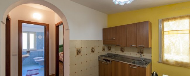 Cucina semplice con vista sul bagno.