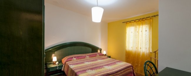 Camera con letto matrimoniale e tende gialle.
