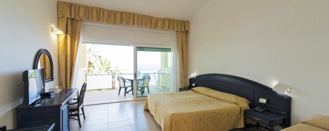 Camera da letto con balcone affacciato sul mare.
