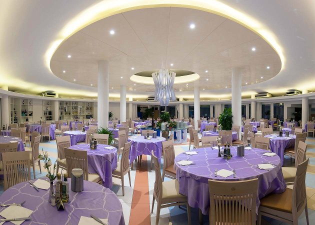 Ristorante elegante con tavoli apparecchiati in viola.
