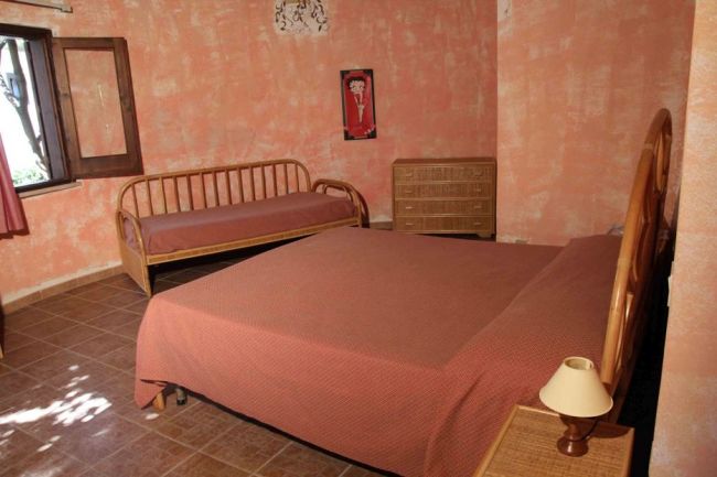 Camera da letto con letto matrimoniale e pareti arancioni.