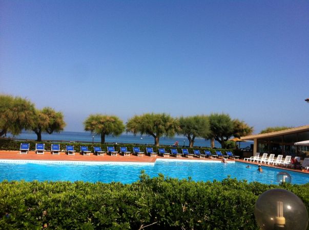 Piscina scoperta con lettini e vista mare.